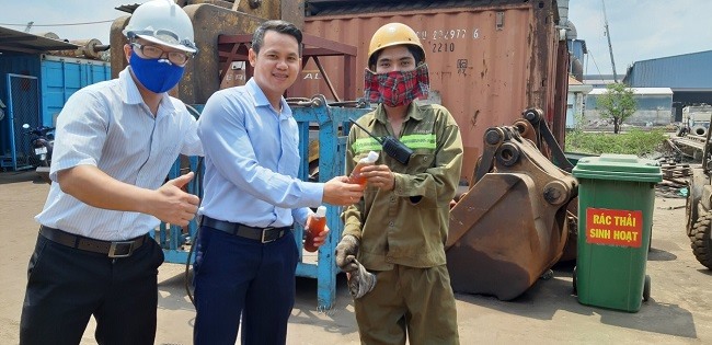 Những chai nước mát được trao tận tay người lao động tại cầu cảng. Ảnh: Diệu Linh