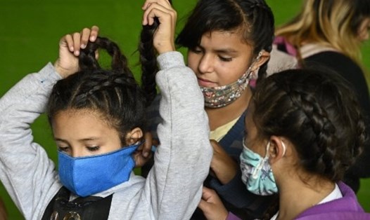 Trẻ em đeo khẩu trang để ngăn ngừa sự lây lan của COVID-19. Ảnh: AFP