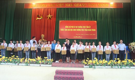 Các đồng chí lãnh đạo trao quà là những chiếc đèn bàn chống cận cho học sinh có hoàn cảnh khó khăn. Ảnh: Nguyễn Thị Mơ.