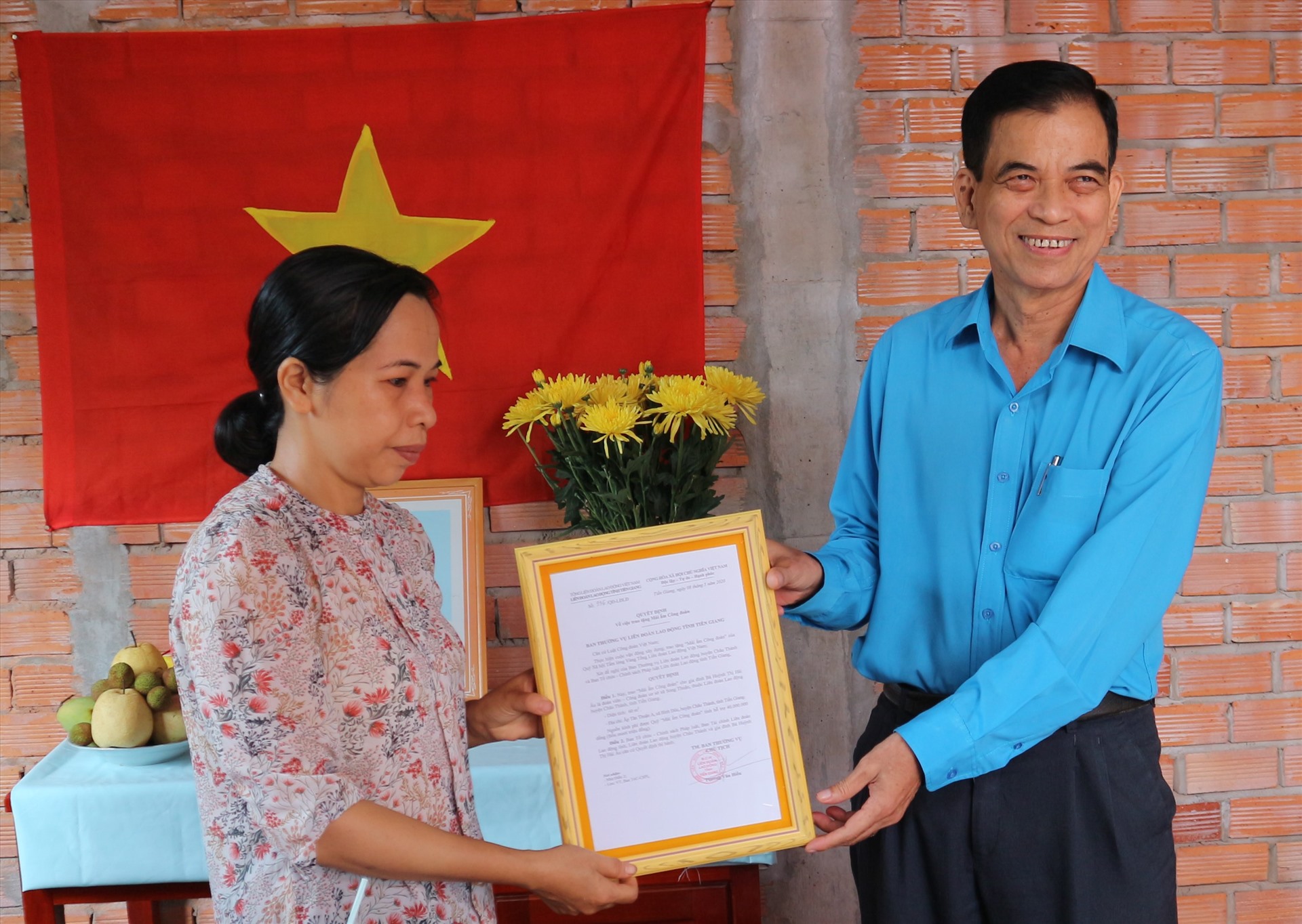 Đồng chí Trương Văn Hiền Chủ tịch LĐLĐ tỉnh trao quyết định bàn giao nhà Mái ấm Công đoàn cho đoàn viên. Ảnh: Lý Oanh