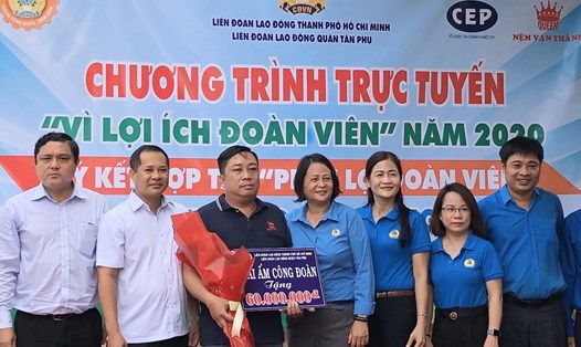 Anh Trần Thanh Tùng (thứ ba, từ trái qua) nhận biển tượng trưng số tiền 60 triệu đồng do LĐLĐ quận Tân Phú, TPHCM trao tặng để xây dựng nhà Mái ấm Công đoàn. Ảnh: Thu Hà
