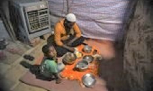 Người Rohingya đang ăn trong những túp lều ở trại tị nạn. Ảnh: AFP