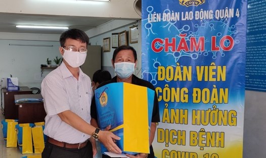 Chủ tịch LĐLĐ Quận 4 Trần Văn Thanh Hùng trao quà cho đoàn viên bị ảnh hưởng việc làm do dịch COVID-19. Ảnh Đức Long