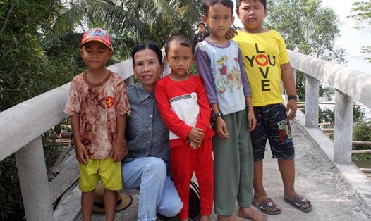 Trẻ nhỏ vui mừng bên bà Phan Kim Nhẹ khi có cầu đến trường. Ảnh: Sở Hạ