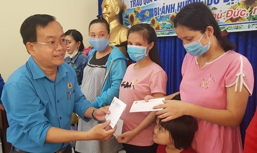 Ông Phạm Văn Hiền, Phó Chủ tịch Công đoàn các KCX&CN TPHCM tặng quà cho các nữ công nhân của Công ty Yesum Vina đang có thai, nuôi con nhỏ. Ảnh Đức Long