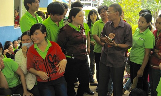 Nhà báo Dương Minh Đức (người đứng bên phải) đang tiếp xúc với công nhân lao động - Ảnh Phạm Thọ