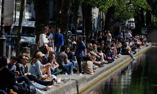 Người dân ngồi trên bờ kênh Saint-Martin ở Paris hôm 16.5 vào cuối tuần đầu tiên sau khi Pháp nới lỏng các biện pháp hạn chế. Ảnh: AFP