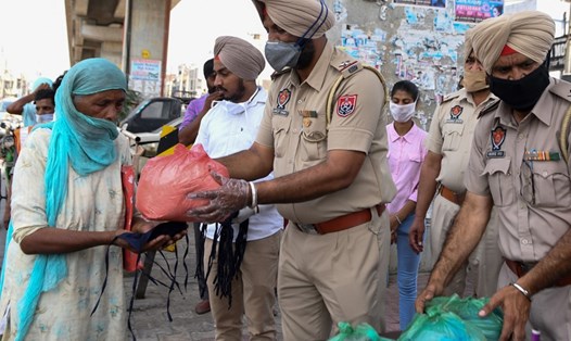 Cảnh sát phân phát hàng viện trợ cho những người dân có nhu cầu ở Amritsar, Ấn Độ hôm 1.5. Ảnh: AFP.