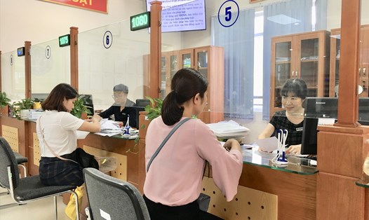 Cán bộ Bảo hiểm xã hội (BHXH) Việt Nam hướng dẫn người dân thực hiện hồ sơ tham gia BHXH tự nguyện. Ảnh: H.A