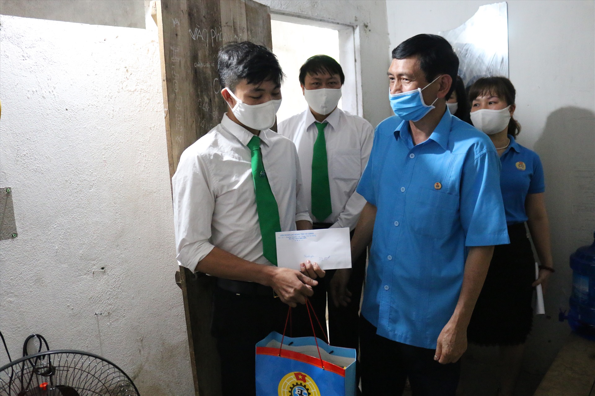 Đồng chí Nguyễn Văn Chung - Chủ tịch Liên đoàn Lao động tỉnh Hà Giang - trao quà cho công nhân lao động khó khăn. Ảnh: Hùng Mạnh.