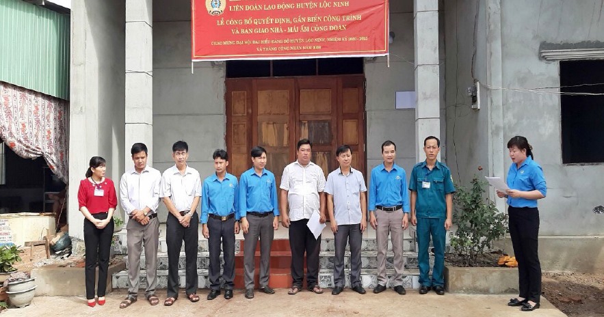 Bà Đinh Thị Mỹ Hạnh-Chủ tịch LĐLĐ huyện công bố quyết định gắn biển công trình thi đua và bàn gia nhà Mái ấm Công đoàn cho đoàn viên. Ảnh Ngọc Huy