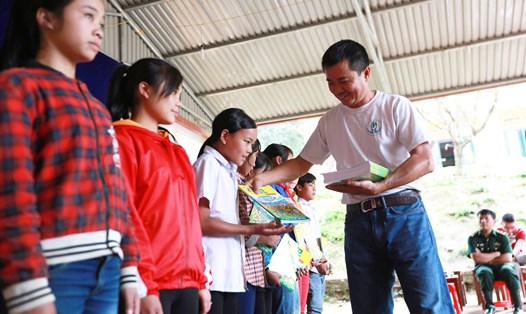Anh Mai Thành Tiến trao tặng sách, truyện của Thư viện Hạt mầm xanh tới học sinh trường Dân tộc Nội trú Y Tý (Lào Cai). Ảnh: Hải Nguyễn
