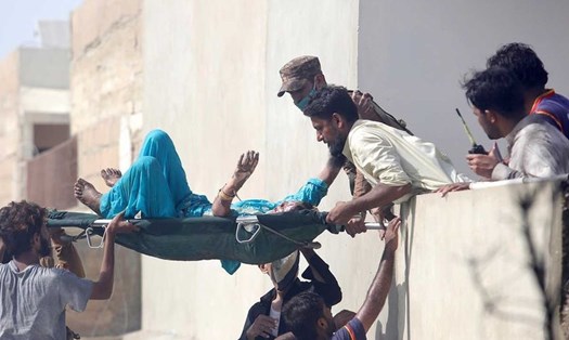 Lực lượng cứu hộ di chuyển một người bị thương tại hiện trường vụ tai nạn máy bay ở thành phố Karachi, Pakistan. Ảnh: Gulf News.