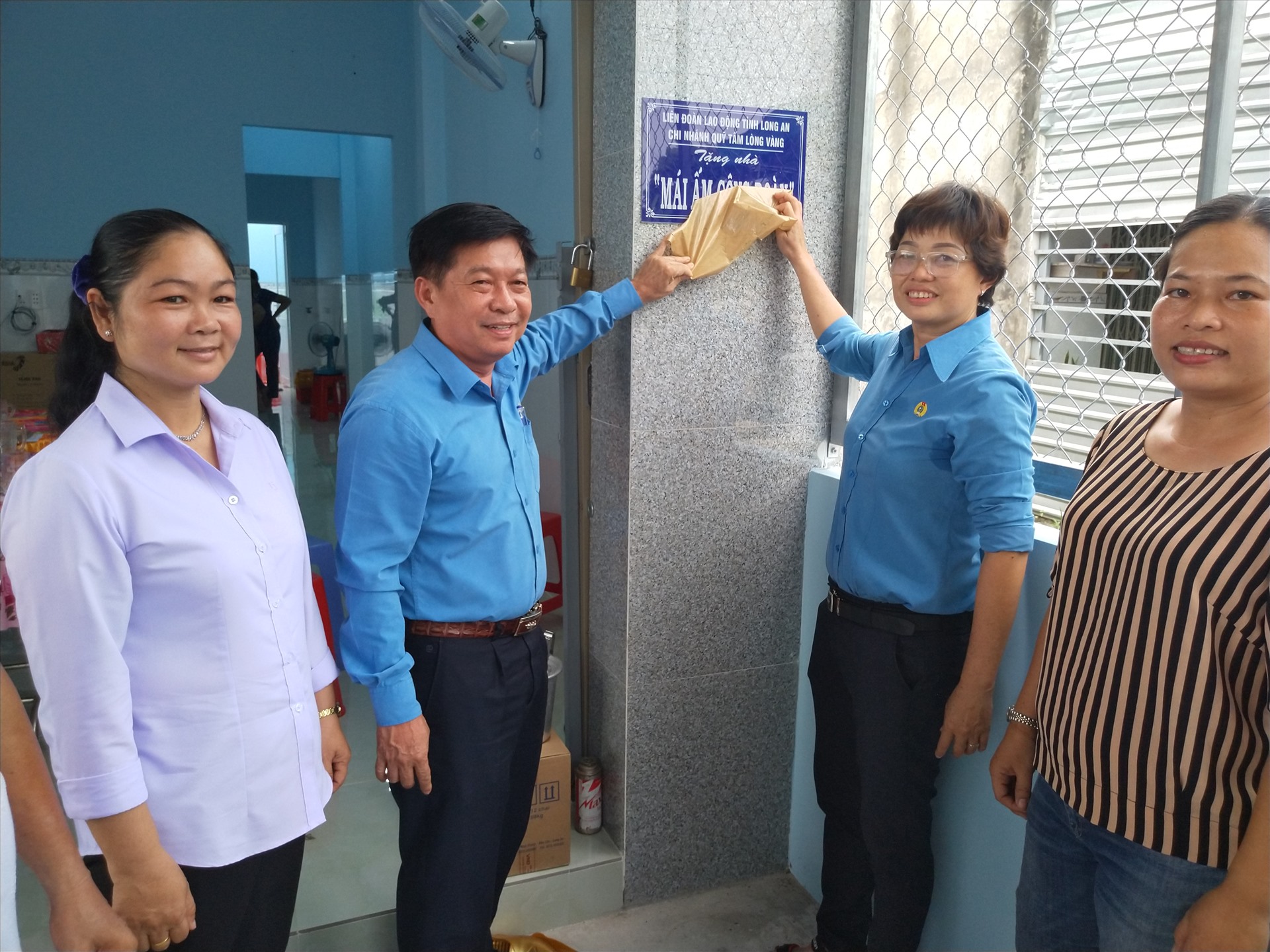 Ông Nguyễn Văn Quí - Chủ tịch LĐLĐ tỉnh Long An và bà Nguyễn Thị Thu Tâm - Chủ tịch LĐLĐ huyện Thủ Thừa mở biển công trình bàn giao "Mái ấm Công đoàn". Ảnh: K.Q