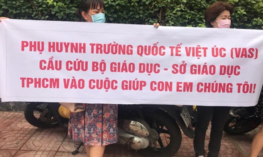 Phụ huynh Trường Dân lập quốc tế Việt Úc tập trung sáng 23.5 với nhiều băng rôn mong sự giúp đỡ. Ảnh: Tuệ Nhi