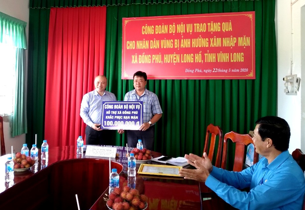 Ông Vũ Đăng Minh - Chánh Văn phòng, Chủ tịch Công đoàn Bộ Nội vụ trao tặng số tiền hỗ trợ 100.000.000 đồng cho chính quyền xã Đồng Phú. Ảnh: Thanh Thủy