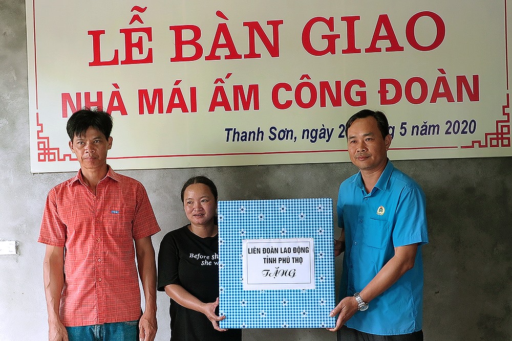 Lãnh đạo LĐLĐ tỉnh tặng quà chúc mừng gia đình có ngôi nhà mới. Ảnh: Anh Hoàng.