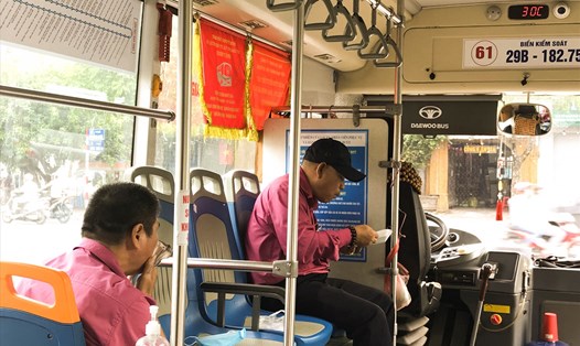 Lái xe, phụ xe buýt 61 ăn bữa sáng vội vã trên xe tại điểm cuối Công viên Cầu Giấy (Hà Nội). Ảnh: Thanh Thanh