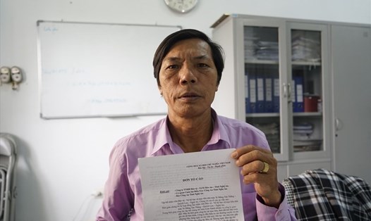 Ông Ngô Xuân Phấn - nhân viên Công ty bảo vệ Bảo An (TP.Vinh-Nghệ An) và lá đơn tố cáo về việc bị Giám đốc đánh đập. Ảnh: Quang Đại