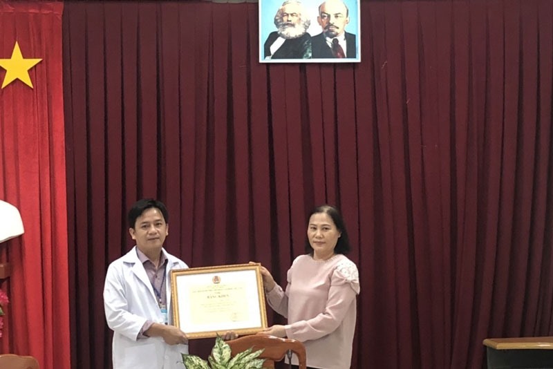 Bà Đặng Thị Kim Đang, Phó Chủ tịch LĐLĐ tỉnh Đồng Tháp, trao Bằng khen cho bác sĩ Lâm. Ảnh: Thanh Nghĩa