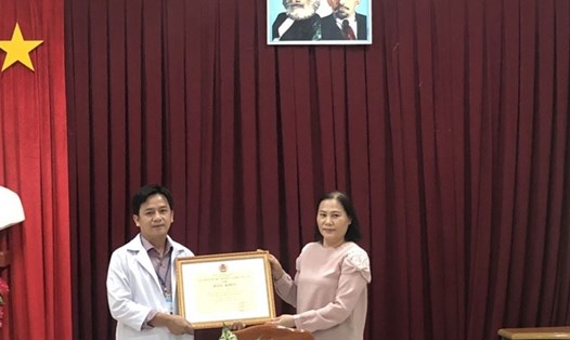 Bà Đặng Thị Kim Đang, Phó Chủ tịch LĐLĐ tỉnh Đồng Tháp, trao Bằng khen cho bác sĩ Lâm. Ảnh: Thanh Nghĩa