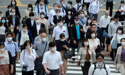 Người dân đeo khẩu trang đi trên đường phố ở Tokyo hôm 26.5. Ảnh: AFP.
