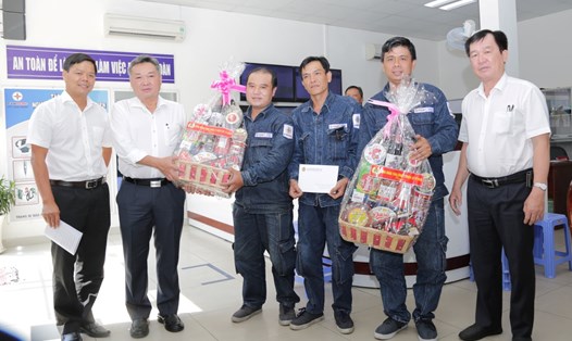 Ông Phạm Quốc Bảo (thứ hai từ trái qua) và Chủ tịch Công đoàn EVNHCMC Lê Văn Minh (bên trái), tặng quà công nhân. Ảnh EVNHCMC cung cấp.