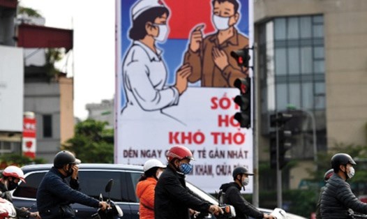 Áp phích tuyên truyền phòng chống COVID-19 trên đường phố Hà Nội. Ảnh: AFP