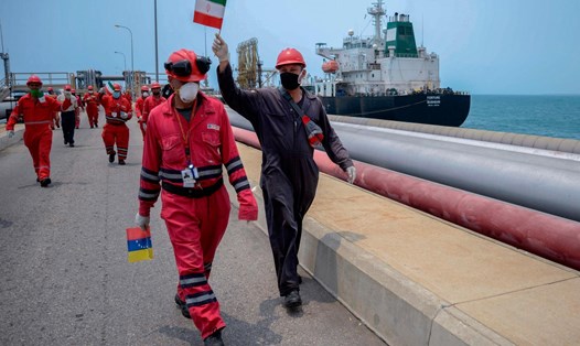 Công nhân công ty dầu mỏ nhà nước Venezuela PDVSA vẫy cờ Iran khi tàu chở dầu Fortune cập cảng tại nhà máy lọc dầu El Palito ở Puerto Cabello, thuộc bang Carabobo, miền bắc Venezuela. Ảnh: AFP