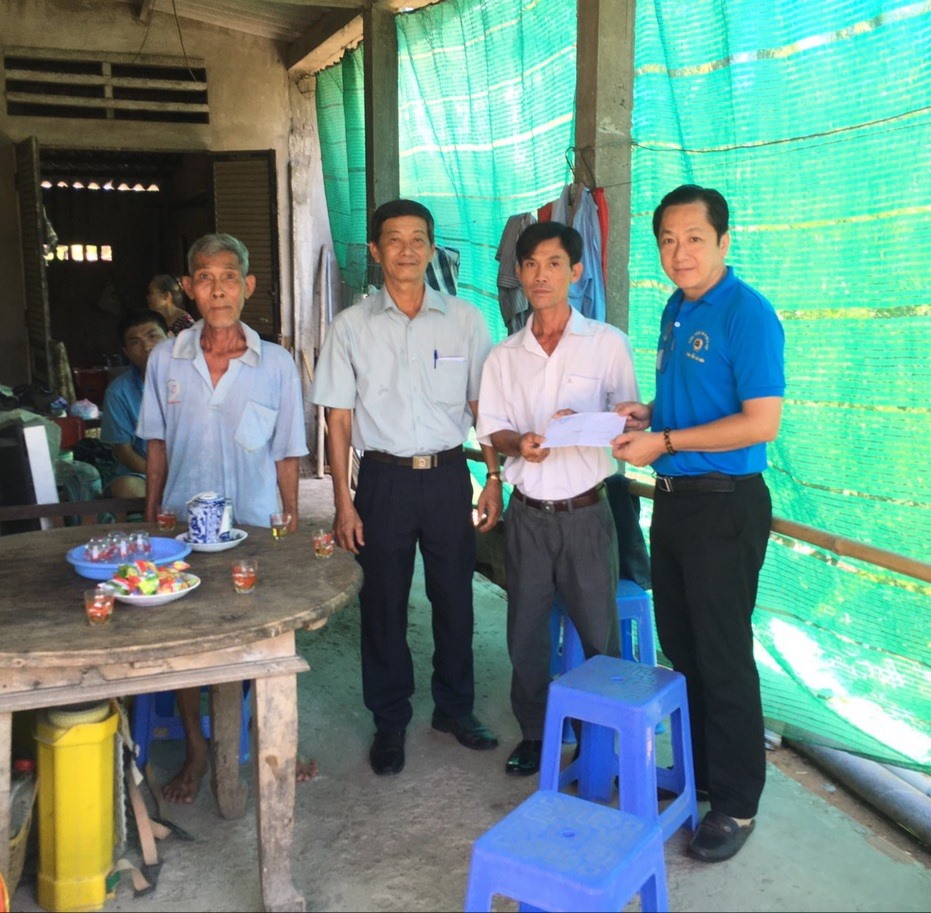 Chủ tịch Công đoàn ngành Giáo dục Tiền Giang - ông Lưu Nhơn Đức - trao tiền hỗ trợ cho gia đình bị thiên tai. Ảnh: L.N.Đ