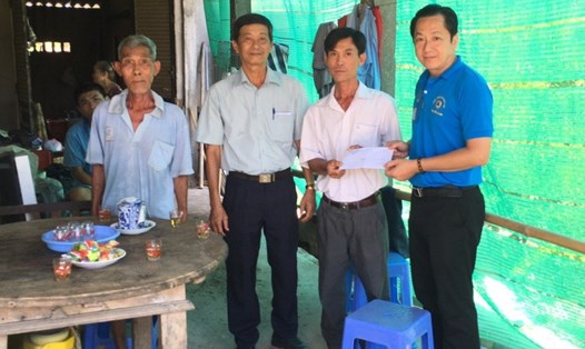 Chủ tịch Công đoàn ngành Giáo dục Tiền Giang - ông Lưu Nhơn Đức - trao tiền hỗ trợ cho gia đình bị thiên tai. Ảnh: L.N.Đ