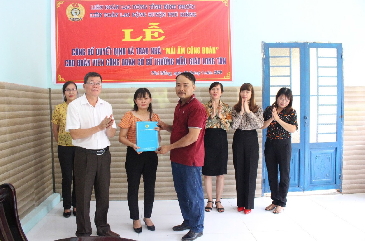 Ông Trương Văn Cương- Chủ tịch Liên đoàn Lao động huyện Phú Riềng trao quyết định tặng nhà cho gia đình đoàn viên Hoàng Mỹ Quyền. Ảnh LĐLĐ Phú Riềng