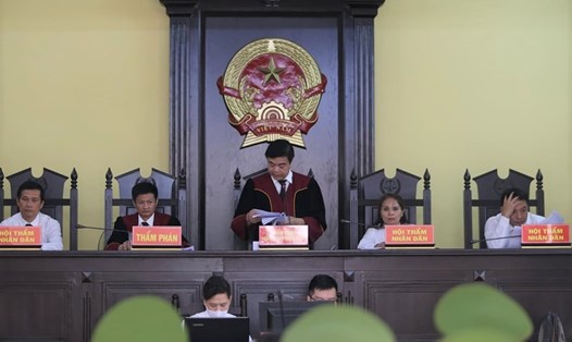 Chủ tọa Quản Hữu Chiến (đứng, ở giữa) công bố bản án với các bị cáo trong vụ sửa, nâng điểm thi kỳ thi THPT quốc gia 2018 tại Sơn La. Ảnh: Hoàng Việt.