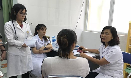 Các bác sĩ BV Hữu nghị Việt Đức đang tư vấn cho một phụ huynh sau khi khám cho trẻ. Ảnh: Thùy Linh