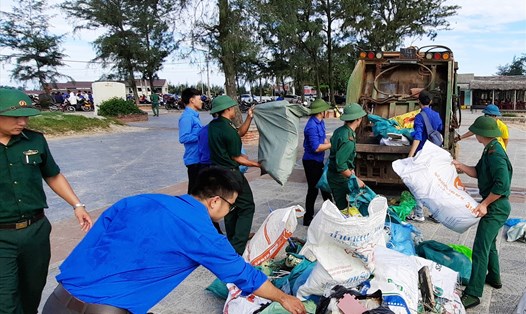 Đoàn viên, thanh niên, cán bộ chiến sĩ nhặt rồi gom rác ở bãi tắm Cửa Việt (huyện Gio Linh, tỉnh Quảng Trị). Ảnh: Tú Anh.