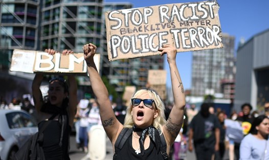 Người biểu tình mang theo những tấm khẩu hiệu phản đối phân biệt sắc tộc trong khi diễu hành bên ngoài Đại sứ quán Mỹ ở London hôm 31.5. Ảnh: AFP.