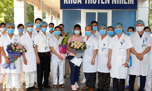 Đại diện lãnh đạo Bệnh viện Đa khoa tỉnh Ninh Bình tặng hoa chúc mừng bệnh nhân 166 và đội ngũ cán bộ y bác sĩ tại Khoa truyền nhiễm. Ảnh: NT
