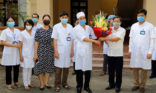 Đại diện lãnh đạo Bệnh viện Đa khoa huyện Kim Sơn tặng hoa chúc mừng đội ngũ y bác sĩ Khoa truyền nhiễm đã điều trị khỏi cho bệnh nhân 170. Ảnh: NT