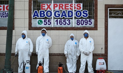 Các nhân viên y tế đang nghỉ ngơi trong lúc phun khử trùng khu phố Iztapalapa tại thành phố Mexico, trong nỗ lực ngăn ngừa lây lan COVID-19. Ảnh: AFP