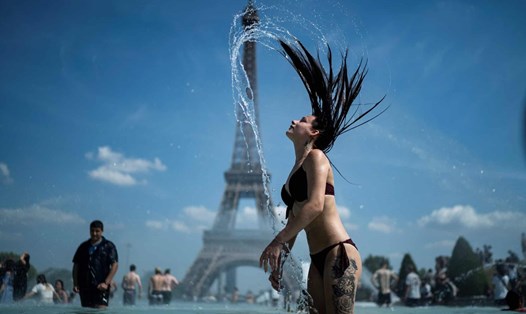 Một người phụ nữ tại đài phun nước Trocadéro, ở Paris, Pháp trong đợt nắng nóng kỷ lục ở Châu Âu. Ảnh: AFP.
