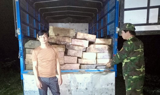 Tài xế Phong cùng hàng chục phách gỗ lậu lúc bị bắt giữ. Ảnh: BĐBP cung cấp.