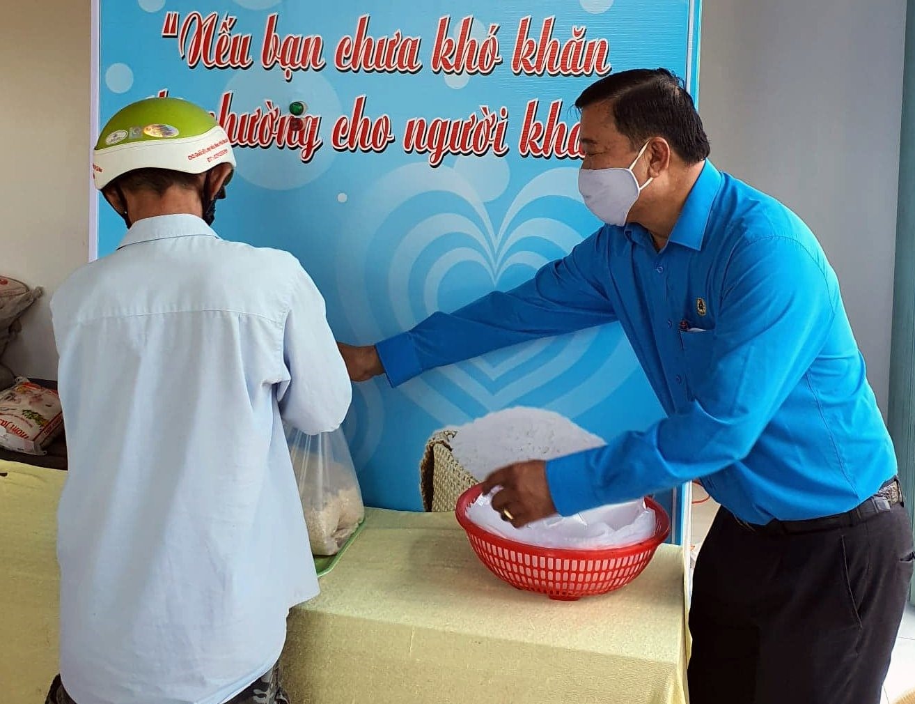 Chủ tịch LĐLĐ Cà Mau Võ Thanh Tòng hướng dẫn người lao động nhận gạo từ ATM gạo do LĐLĐ Cà Mau tổ chức. Ảnh: Nhật Hồ
