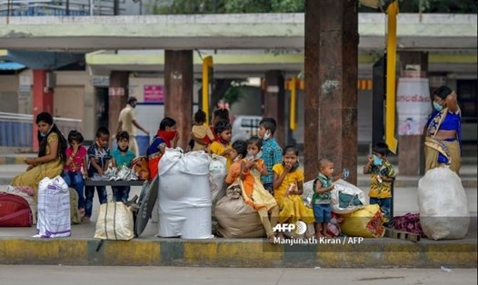 Một gia đình người Ấn Độ chờ xe bus tại Bangalore để trở về quê nhà hôm 7.5. Ảnh: AFP.