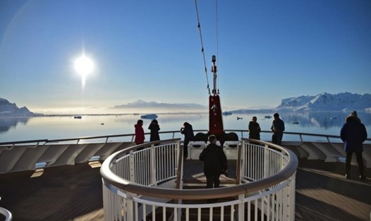 Khách du lịch ngắm mặt trời mọc từ vịnh Chiriguano ở đảo South Shetland, Nam Cực. Ảnh: AFP