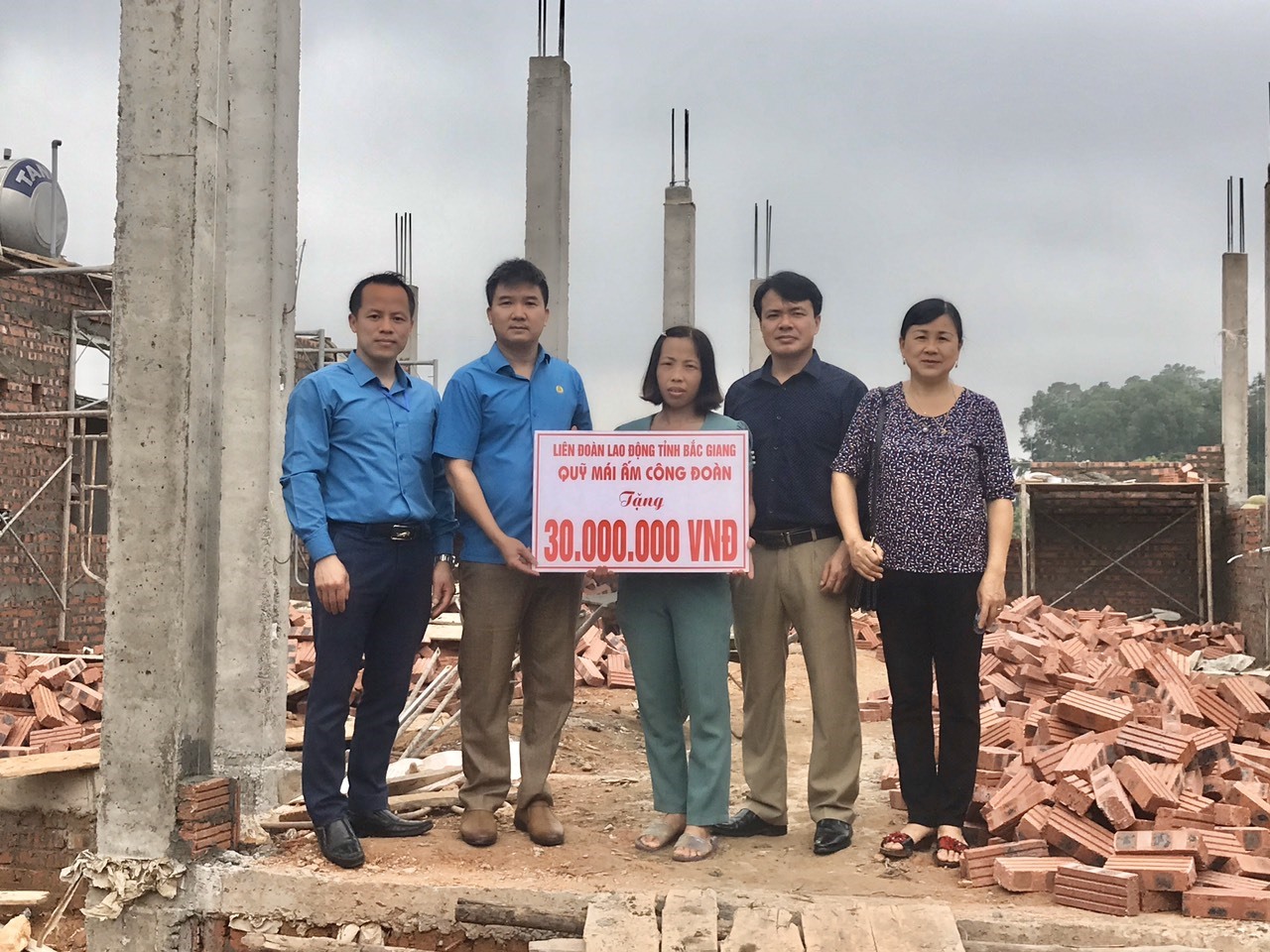 Lãnh đạo LĐLĐ huyện Tân Yên trao kinh phí xây mới nhà ở cho đoàn viên Ngô Thị Huyền. Ảnh: Tân Yên