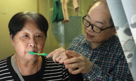 Cụ Lam Man-hing đang giúp vợ Tang Siu-man đánh răng. Ảnh: SCMP.