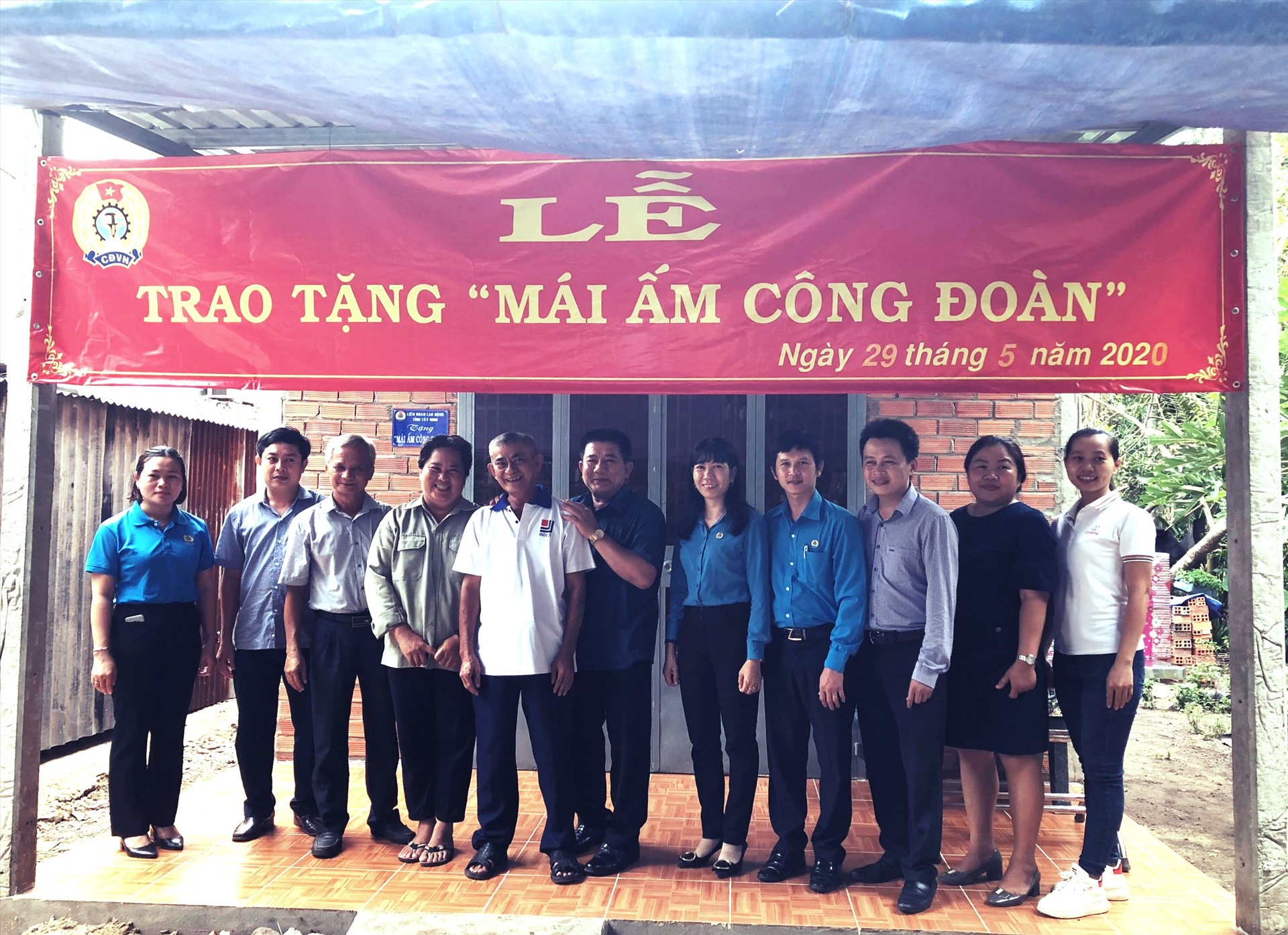 Các đại biểu chụp ảnh lưu niệm với gia đình anh Trần Phước Hùng. Ảnh LĐLĐ Tây Ninh