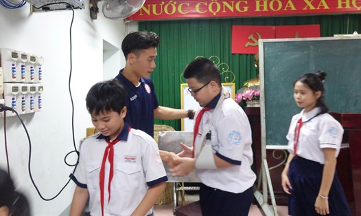 Thủ môn Bùi Tiến Dũng đến thăm các học sinh bị thương trường THCS Bạch Đằng. Ảnh: Nguyễn Đăng