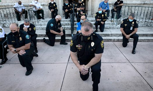 Cảnh sát quì gối trong cuộc biểu tình phản ứng trước cái chết của George Ployd tại Coral Gables, Florida, Mỹ, ngày 30.5. Ảnh: AFP
