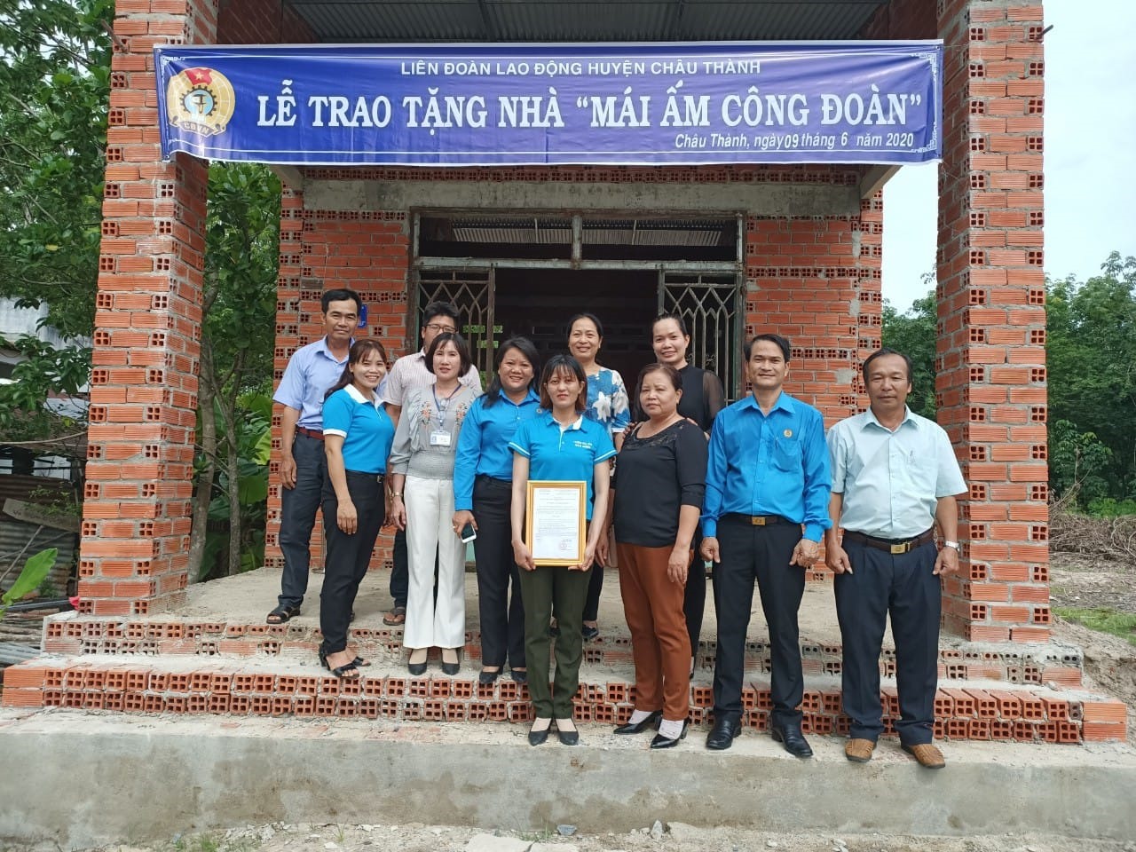 Các đại biểu chụp ảnh lưu niệm với gia đình chị Lê Thị Bé.